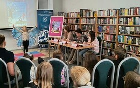 Publiczność ogląda występ dziewczynki ze skrzydłami motyla