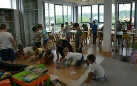 W sali wypełnionej dziećmi trwają warsztaty ilustratorskie.