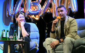 Kobieta i mężczyzna na fotelach podczas panelu dyskusyjnego.