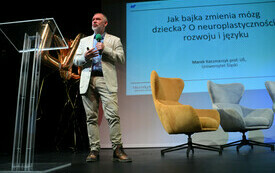 Profesor przemawiający na scenie.