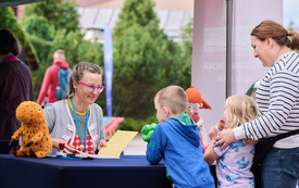 Pisarka rozdaje autografy dzieciom.