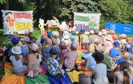 W parku trwają zajęcia czytelnicze dla dzieci.