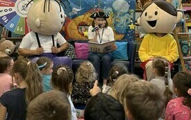 Bibliotekarka w czapce pirata oraz maskotki Bolek i Lolek.