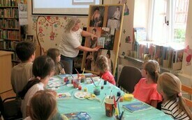 Kobieta prowadzi zajęcia malarskie.