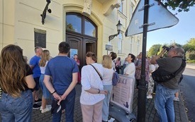 Grupa ludzi zebranych przed wejściem do biblioteki