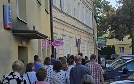 Grupa ludzi idąca chodnikiem na ulicy Jałowego.
