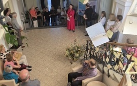 Widok z g&oacute;ry na hol biblioteki, w kt&oacute;rym zebrała się grupa uczestnik&oacute;w spaceru.
