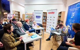 Sala biblioteczna wypełniona siedzącymi czytelnikami