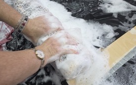 Dłonie kobiety tworzą w pianie.