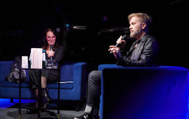 Na scenie gość spotkania i prowadząca spotkanie.