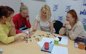 Cztery kobiety patrzą na zdjęcia ułożone na stole