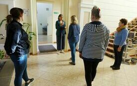 Pięć kobiet stojących na holu biblioteki.