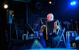 Mężczyzna z akordeonem występuje na scenie. 