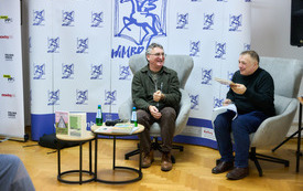 Autor i prowadzący rozmawiają gestykulując i śmiejąc się