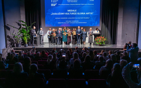 Grupa nagrodzonych bibliotekarzy pozuje do zdjęcia stojąc na scenie