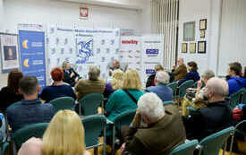 W sali publiczność zebrana na spotkaniu.