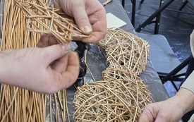 Na stole dwa serca wyplecione z wikliny i wiklina, wyplatanie serca z wikliny.