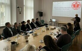 Kobieta w kr&oacute;tkich włosach i okularach podczas prezentacji. 