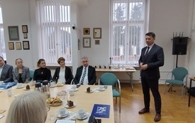 Mężczyzna w garniturze podczas wystąpienia.