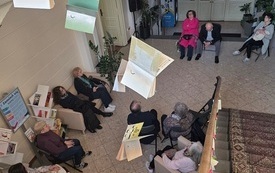 Uczestnicy spotkania zgromadzeni w holu bibliotecznym. 