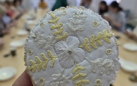 Kawałek materiału w kształcie koła z wyszytym kwiatem