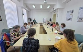 Przy stolikach kobiety podczas wyszywania.