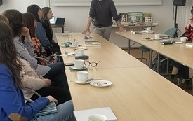 Mężczyzna m&oacute;wi do zebranych na spotkaniu os&oacute;b.