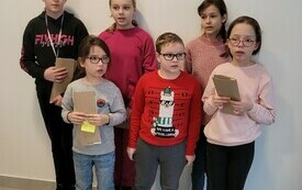 Pięcioro dziewczynek i jeden chłopiec stoją przy ścianie i pozują do zdjęcia.