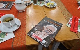 Na stole leży książka, na jej okładce widnieje narysowana postać Franciszka Pieczki.