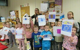 Grupa dzieci prezentuje narysowane przez siebie obrazki