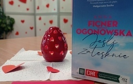 Na stole książka i materiały z logo DKK