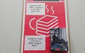 Na tablicy plakat informujący o spotkaniu, książka i logo DKK.