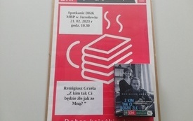 Na tablicy plakat informujący o spotkaniu, książka i logo DKK.