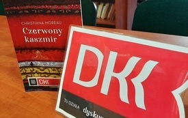 Na stole książka i logo DKK.