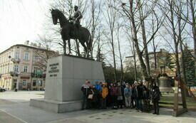 Grupa młodzieży stoi obok pomnika J&oacute;żefa Piłsudskiego w Rzeszowie