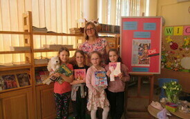 Pisarka pozuje do zdjęcia z dziećmi trzymającymi jej książki