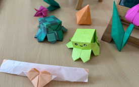 Kolorowe figurki origami leżą na stole