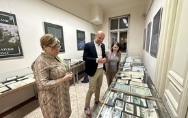 Prezydent Rzeszowa oraz Dyrektor Biblioteki podczas oglądania wystawy zbior&oacute;w biblioteki prezentowanej w gablotach.
