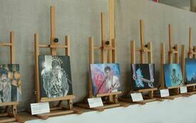 Sztalugi z kolorowymi obrazami przedstawiającymi mężczyznę śpiewającego do mikrofonu, grającego na gitarze.