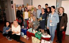 Uczestnicy spotkania, mężczyźni i kobiety w różnym wieku pozują do wspólnej fotografii.