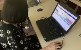 Starsza kobieta podczas przeglądania na laptopie strony internetowej. 