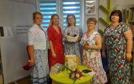 Bibliotekarki pozują do spólnego zdjęcia z autorką książek.