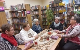 Kilka osób siedzi przy stole i rozmawia.