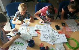 Dzieci podczas warsztat&oacute;w wykonują przedmioty przy użyciu długopisu 3D