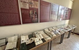 Plansze wystawiennicze z wystawą poświęconą Aleksandrowi Fredrze, poniżej w szklanych gablotach materiały drukowane, książki autora.