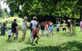 Grupa dzieci wraz z opiekunami w parku. 