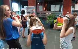 Dzieci uczestniczące w spotkaniu testują okulary VR.