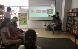 Studentka z Tunezji prowadzi spotkanie o swoim kraju dla dzieci.