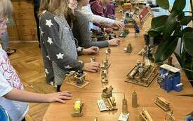 Dzieci oglądające wystawę przedstawiająca dawną wieś w miniaturze