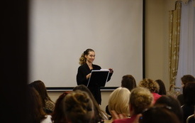 Aleksandra Wajda, wokalistka śpiewa, obok stoi pulpit.